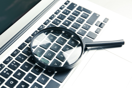 pc portable avec une loupe posée sur le clavier